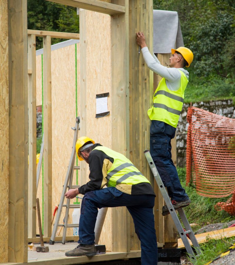 Manual workers working with construction frame at construction site.